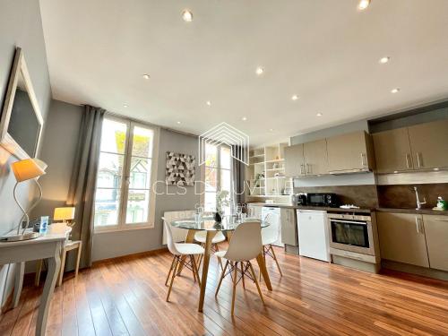 une cuisine avec une table et des chaises dans une pièce dans l'établissement Appartement Coeur de Deauville, à Deauville