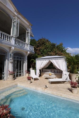 a house with a swimming pool and a gazebo at Villa Caprichosa Boutique Hotels in Taboga