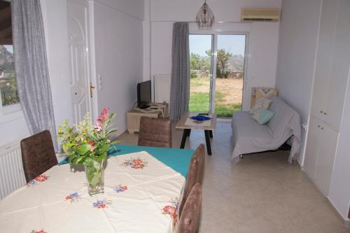 a dining room with a table with a vase of flowers on it at Villa Erofili Plakias south Rethimno Crete in Asómatoi