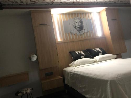 Sofya Suites في فتحية: غرفة نوم بسرير مع صورة رجل