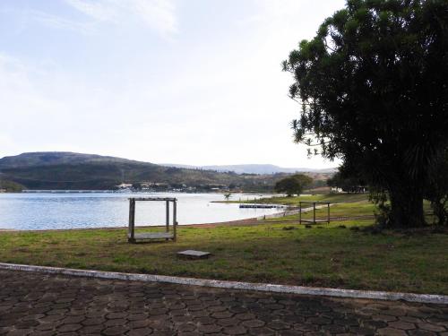 a park next to a body of water with a tree at Pousada Recanto do Turvo in Capitólio