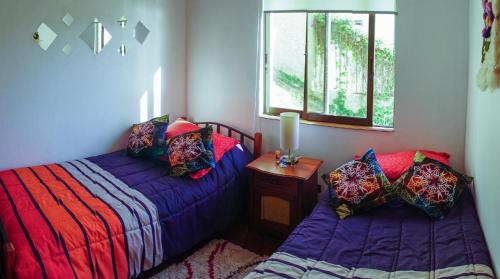 a bedroom with two beds and a window at Depto playa amarilla ConCon in Concón
