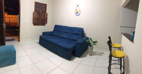 a living room with a blue couch and stool at Casa Aconchegante em Areia in Areia