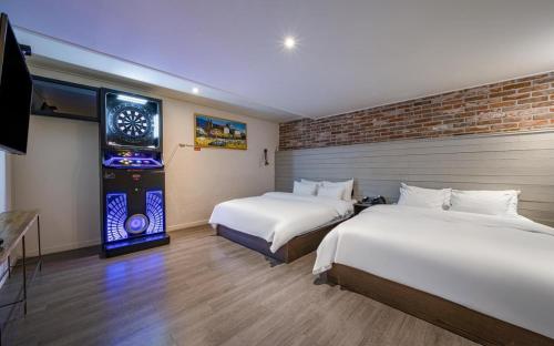una habitación de hotel con 2 camas y un videojuego en HOTEL YaJa WestGate en Cheongju