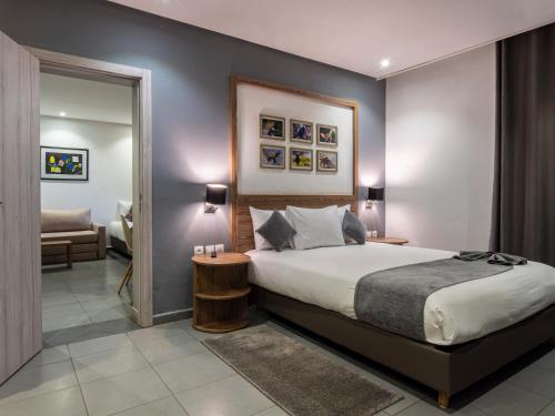 1 dormitorio con 1 cama grande y espejo en Wazo Appart-Hôtel en Marrakech