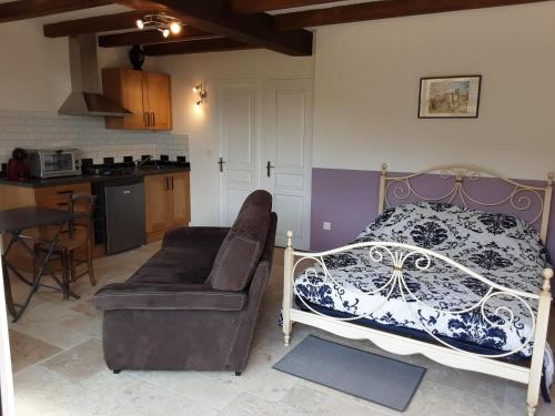 Cet appartement comprend une chambre avec un lit et un canapé ainsi qu'une cuisine. dans l'établissement Stone House in France with Pool & Vineyards, à Chambonas