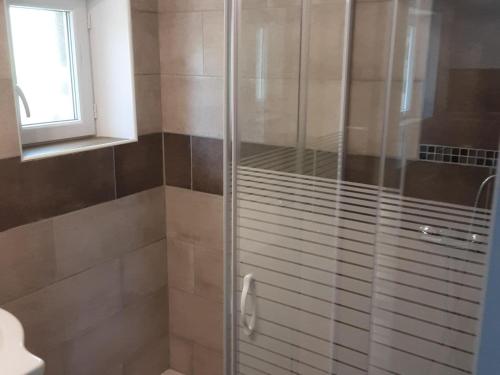W łazience znajduje się prysznic ze szklanymi drzwiami. w obiekcie Tiny house with shared pool in Chambonas w mieście Chambonas