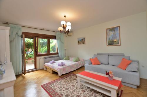 a living room with a couch and a bed at Apartment Kivi in Valbandon