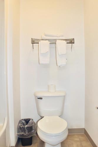 a white bathroom with a toilet and towels at AmeriVu Inn And Suites in Stanley