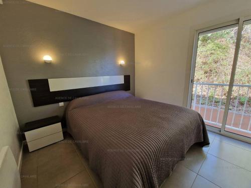 une chambre avec un lit et une grande fenêtre dans l'établissement Appartement T3 à Cavalaire-sur-Mer - Terrasse vue mer et parking - FR-1-100-271, à Cavalaire-sur-Mer