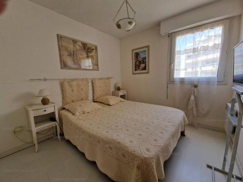 a white bedroom with a bed and a window at T3 au centre de Cavalaire avec parking, clim, wifi, proche plage - FR-1-100-272 in Cavalaire-sur-Mer