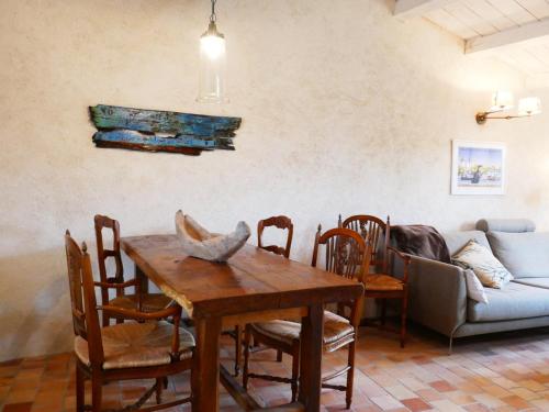 une salle à manger avec une table, des chaises et un canapé dans l'établissement Charmante maison rénovée avec goût, jardin clos, accès wifi, proche commerces et mer. - FR-1-224B-160, à Noirmoutier-en-l'lle