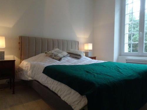 une chambre avec un grand lit avec une couverture verte dans l'établissement Maison en pierre rénovée, 8 couchages, terrasse bois, proche bois de la Chaise - FR-1-224B-162, à Noirmoutier-en-l'lle