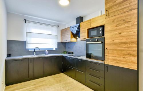 a kitchen with brown cabinets and a sink and a microwave at Beautiful Home In Klostar Ivanic in Kloštar Ivanić