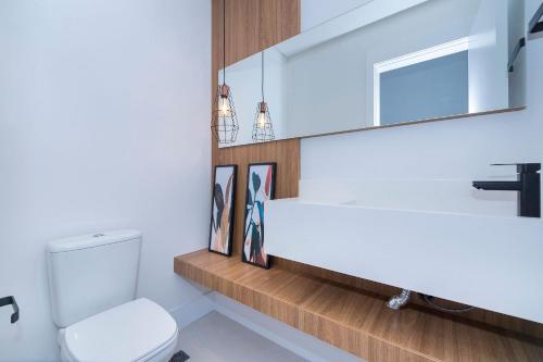 a bathroom with a white toilet and a sink at Adra 306 - Excelente Cobertura Duplex - Centro/Bombinhas- Rooftop com Piscina - À poucos metros da praia - (Consultar serviços de roupas de cama e banho) in Bombinhas