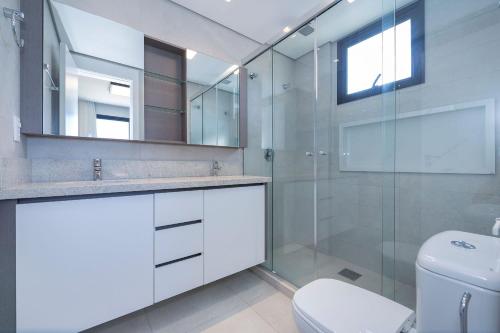 ein Badezimmer mit Glasdusche und Toilette in der Unterkunft Adra 301 - Apartamento no centro de Bombinhas - Rooftop com piscina e academia - À poucos metros da praia - (Consultar serviços de roupas de cama e banho) in Bombinhas