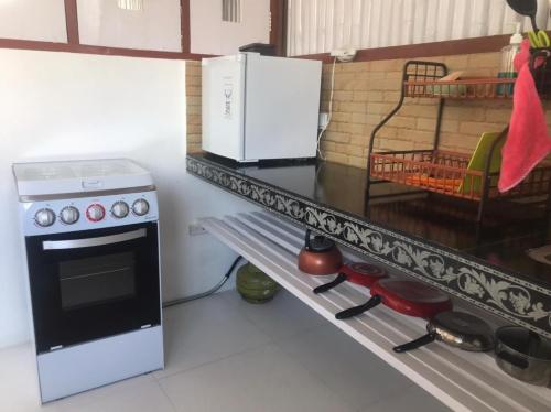 a kitchen with a stove and a microwave on a counter at BALI AMED FEEL HOME VILLA in Amed