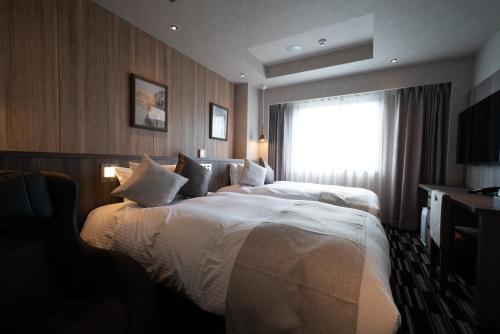 A bed or beds in a room at Hotel Grand View Takasaki