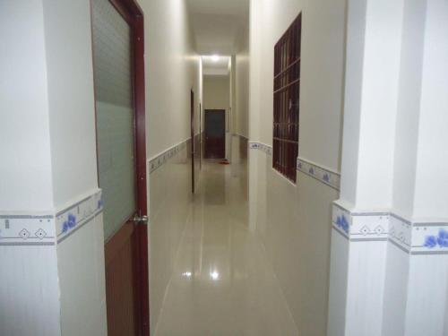 a hallway with a long corridor with a door and a room at NHÀ NGHỈ THUỲ NHUNG 1 in Phú Quốc