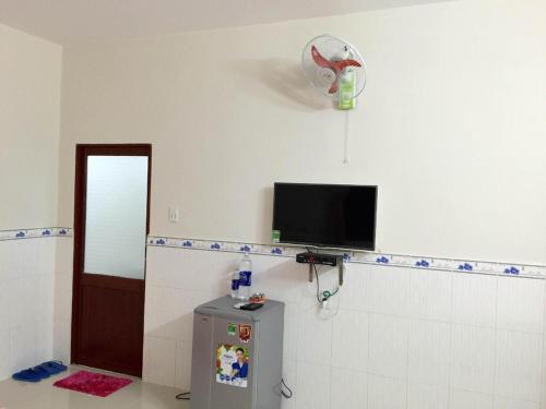 ein Bad mit einem Kühlschrank und einem Ventilator an der Wand in der Unterkunft NHÀ NGHỈ THUỲ NHUNG 1 in Phu Quoc