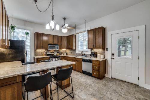 a kitchen with wooden cabinets and a counter top at Downtown Historic 2Bdrm, Walk to Riverwalk, Alamo; Beautifully Renovated! in San Antonio
