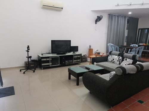 a living room with a couch and a tv at Bp Pool homestay28 in Batu Pahat