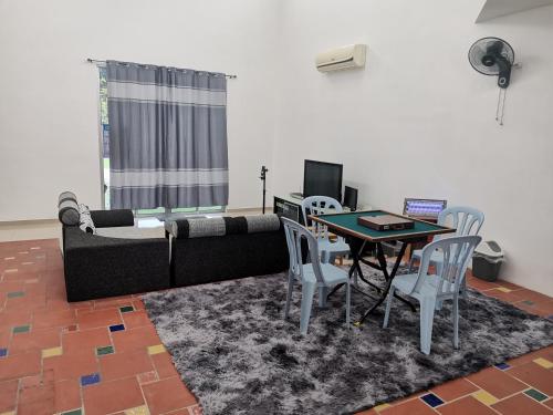a living room with a couch and a table and chairs at Bp Pool homestay28 in Batu Pahat