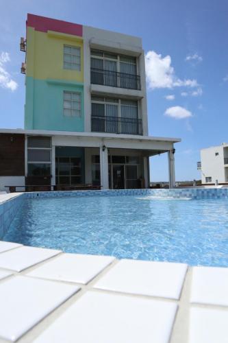 a building with a swimming pool in front of a building at Let's Play B&B 七桃旅宿 in Nanwan