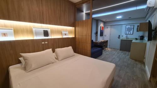 1 dormitorio con 1 cama blanca grande y cocina en Costa Sul Beach Hotel, en Balneário Camboriú