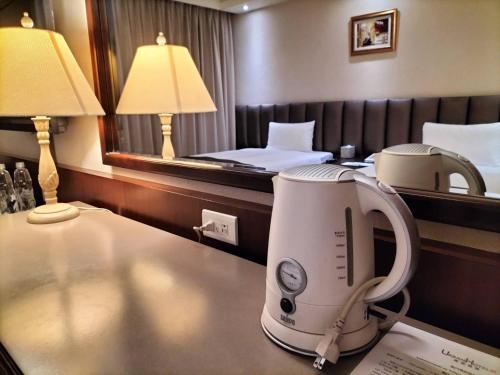 a hotel room with a coffee machine on a table at Urban Hotel33 in Kaohsiung