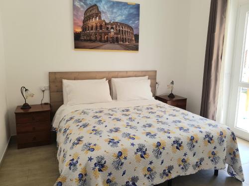 a bedroom with a bed with a floral comforter at un passo dal mare in Fiumicino