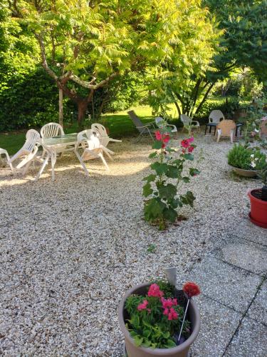 a garden with chairs and a bench and flowers at Chambre de caractere in Celles