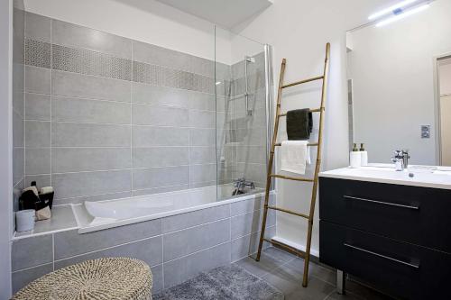 La salle de bains est pourvue d'une baignoire et d'un lavabo. dans l'établissement Superbe appart 3 p, 10 mn de la plage avec piscine et parking, à Marseille
