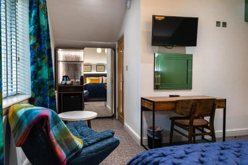 a living room with a desk and a television at The Swan Inn in Highpeak Junction