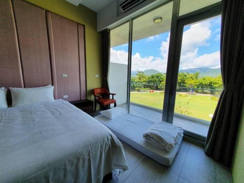 1 dormitorio con ventana grande con vistas a un campo en Splendi Villa, en Hengchun