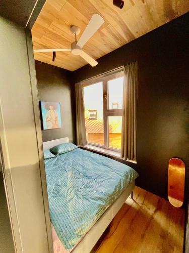 a small bedroom with a bed and a window at Jaukūs ART stiliaus apartamentai antrame aukšte su vaizdu į marias in Svenele