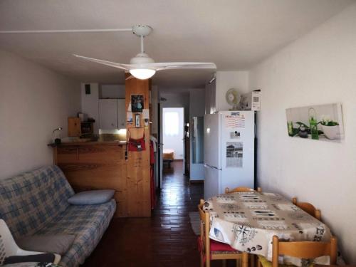 un salon avec un canapé et une table et une cuisine dans l'établissement Résidence Pointe Vermeille - 2 Pièces pour 6 Personnes 014, au Barcarès