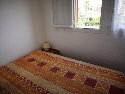 un lit dans une chambre avec une fenêtre dans l'établissement Résidence Pointe Vermeille - 2 Pièces pour 6 Personnes 014, au Barcarès