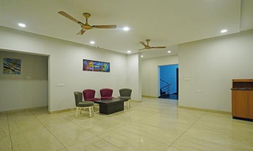 a waiting room with chairs and a table and a ceiling fan at Treebo Lazystay Grand Patia in Bhubaneshwar