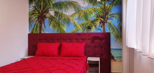 a bedroom with a red bed with palm trees mural at Casa Laur in Sulina