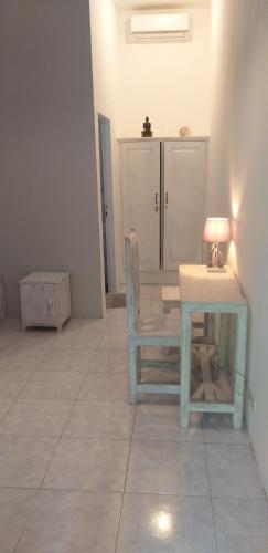 a room with a table and a chair and a lamp at Wombat's B&B in Gili Trawangan