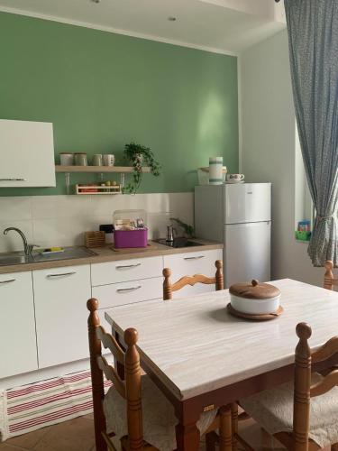 a kitchen with a wooden table and a refrigerator at Appartamento Salvia in centro in Ascea