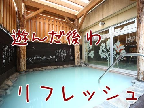 a swimming pool with writing on the side of a building at ふる郷荘Furusato Furano in Furano