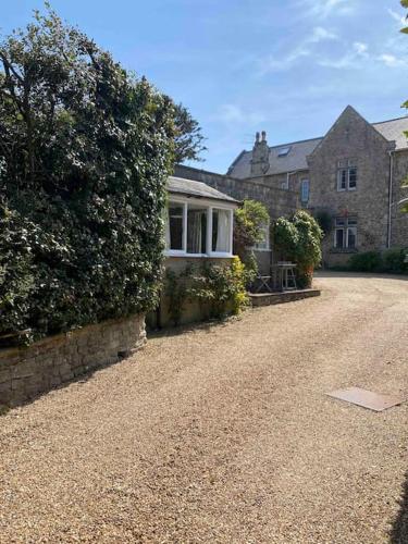 a house with a stone driveway in front of it at The Cottage, ground floor property near the beach in Seaview