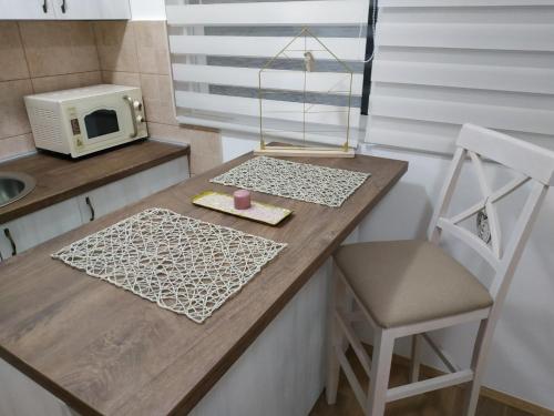 a kitchen with a counter with a microwave and a chair at Sea View Studio in Bečići