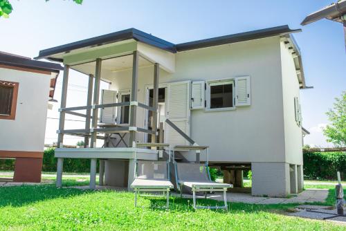 a house with two chairs and a table in the yard at Bungalow Marina di Cortellazzo in Cortellazzo
