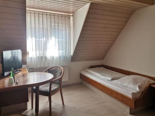 Schlafzimmer mit einem Bett, einem Schreibtisch und einem Tisch in der Unterkunft Engelhof in Weilheim an der Teck