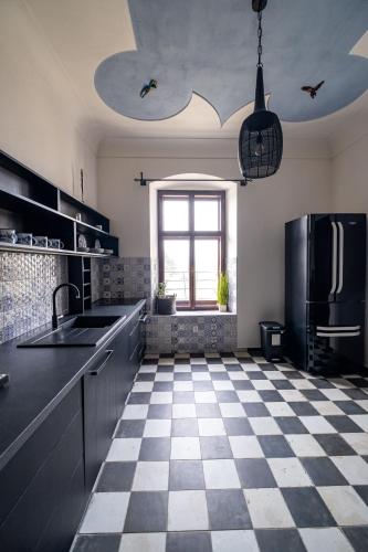 a kitchen with a black refrigerator and a checkered floor at Kníže Ferdinand Apartments in Mikulov