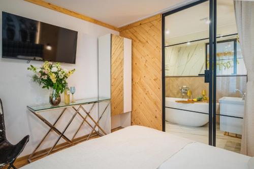 a bedroom with a bathroom with a tub and a sink at GORSKI RESORT Lux Apartments Jacuzzi & Sauna in Poronin