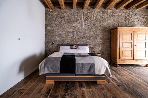 a bedroom with a bed and a stone wall at Kníže Ferdinand Apartments in Mikulov